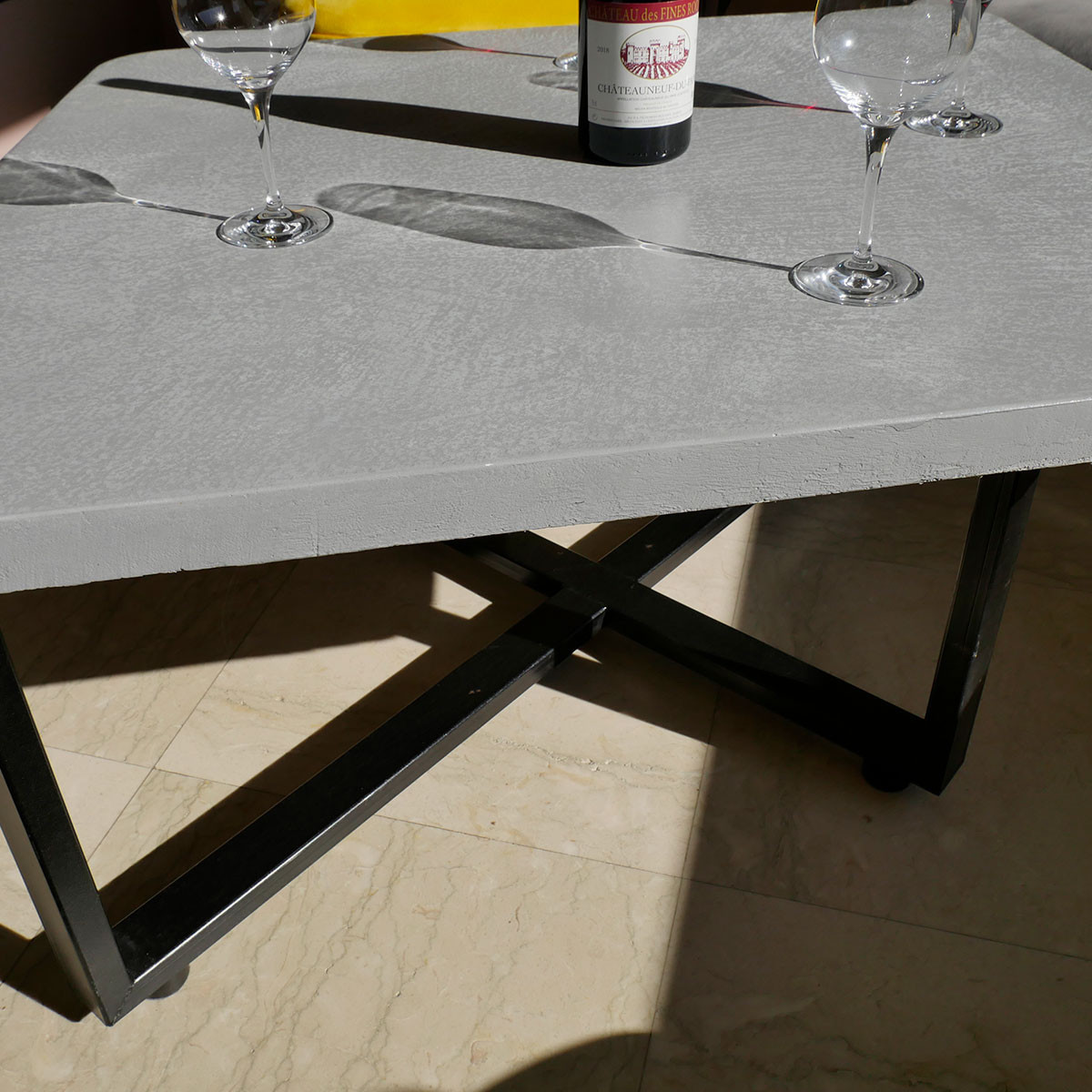 Table basse d'intérieur avec plateau en béton ciré vue de côté