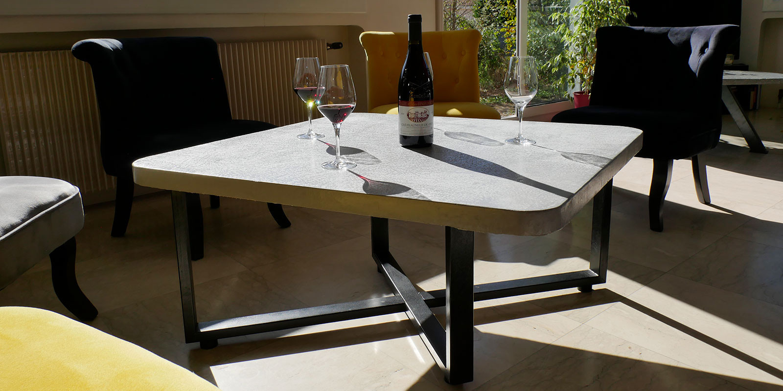 Table d'intérieur en béton ciré gris sur pied en croix noir Table d'intérieur en béton ciré gris sur pied en croix noir